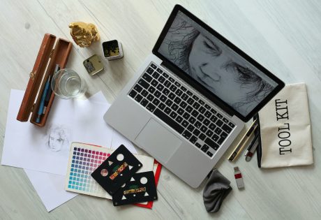 Top view of a creative workspace with a laptop, sketch supplies, and color palette for Digital Marketing Services