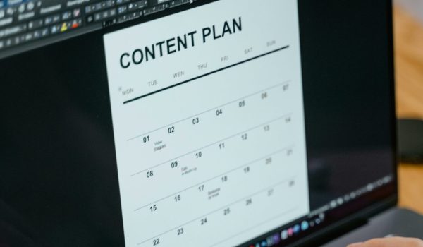Close-up of hands typing on a laptop displaying a content plan document, ideal for business or marketing content.